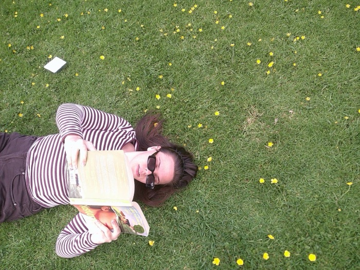 Reading Yesteryear on the grass among buttercups