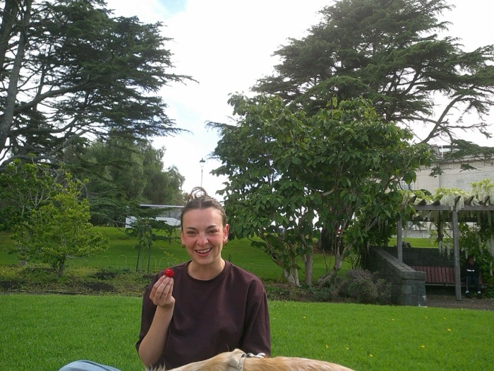 Holding up a strawberry in the park
