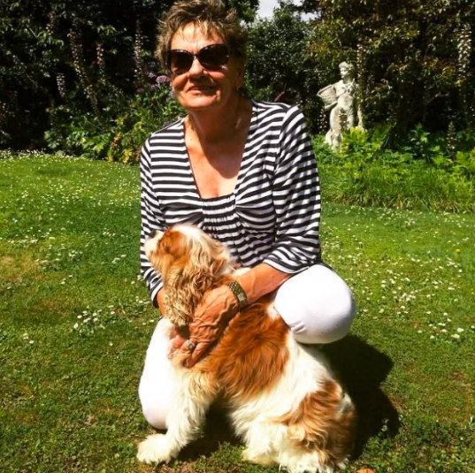 Joy in her garden with her spaniel