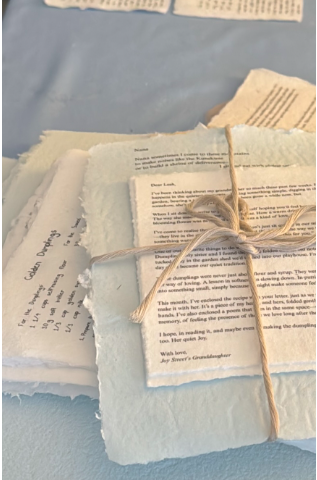 A bundle of handmade poetry pages tied with twine